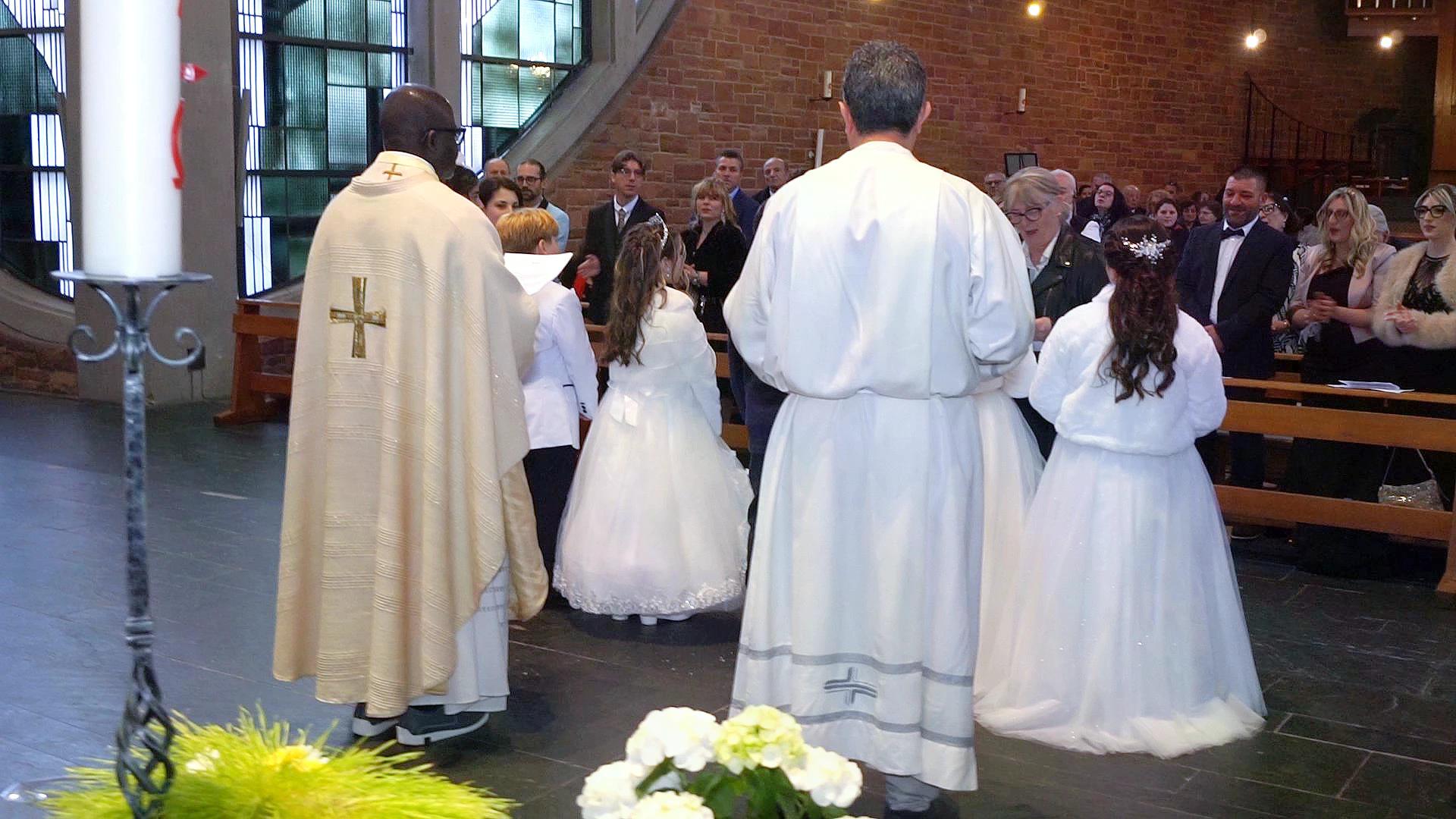 Bambini e Sacerdote durante le Prime Comunioni